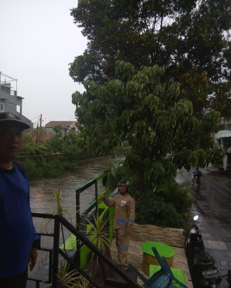 Pastikan Keamanan Warga, Bhabinkamtibmas Polsek Bekasi Barat Pantau Ketinggian Air Kali Cakung