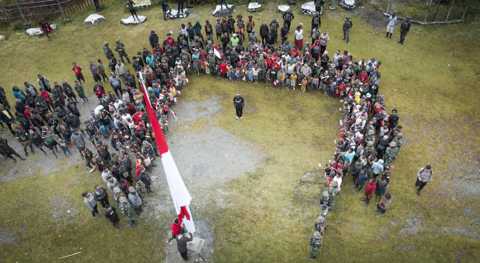 Bersama Masyarakat, Satgas Yonif 715/Motuliato dan Apkam Puncak Jaya Kibarkan Bendera Merah Putih Raksasa di momen tanggal 1 Mei 2025