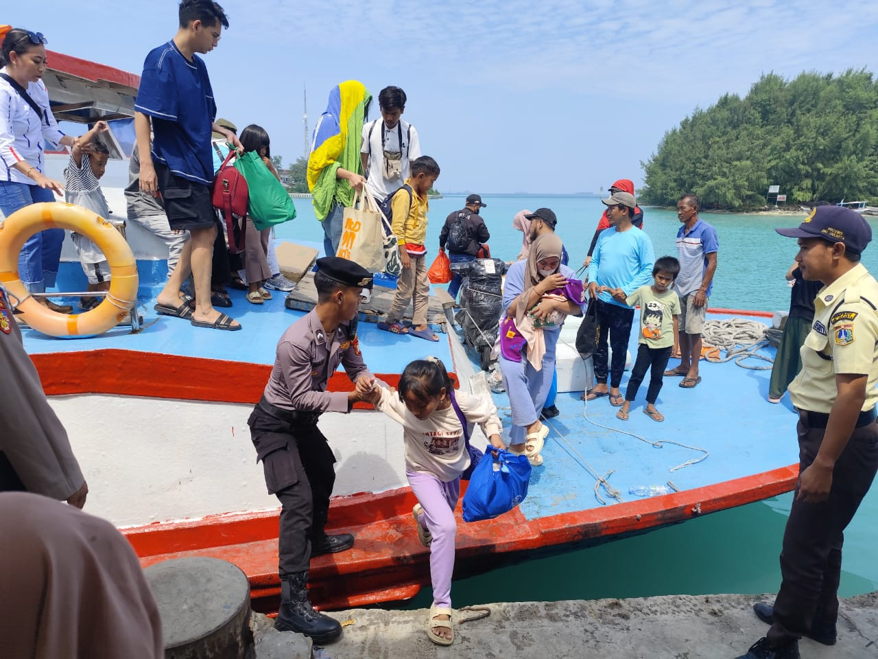 Polisi Baik Polsek Kepulauan Seribu Utara Bantu Penumpang Turun Kapal, Cegah Sajam dan Narkoba Masuk Dermaga