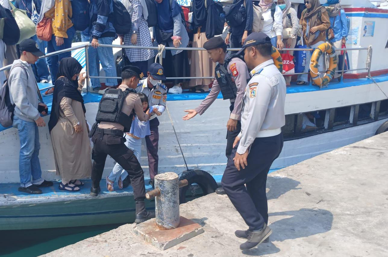 Polisi Humanis Polsek Kepulauan Seribu Utara Bantu Penumpang Turun dari Kapal dan Awasi Barang Bawaan