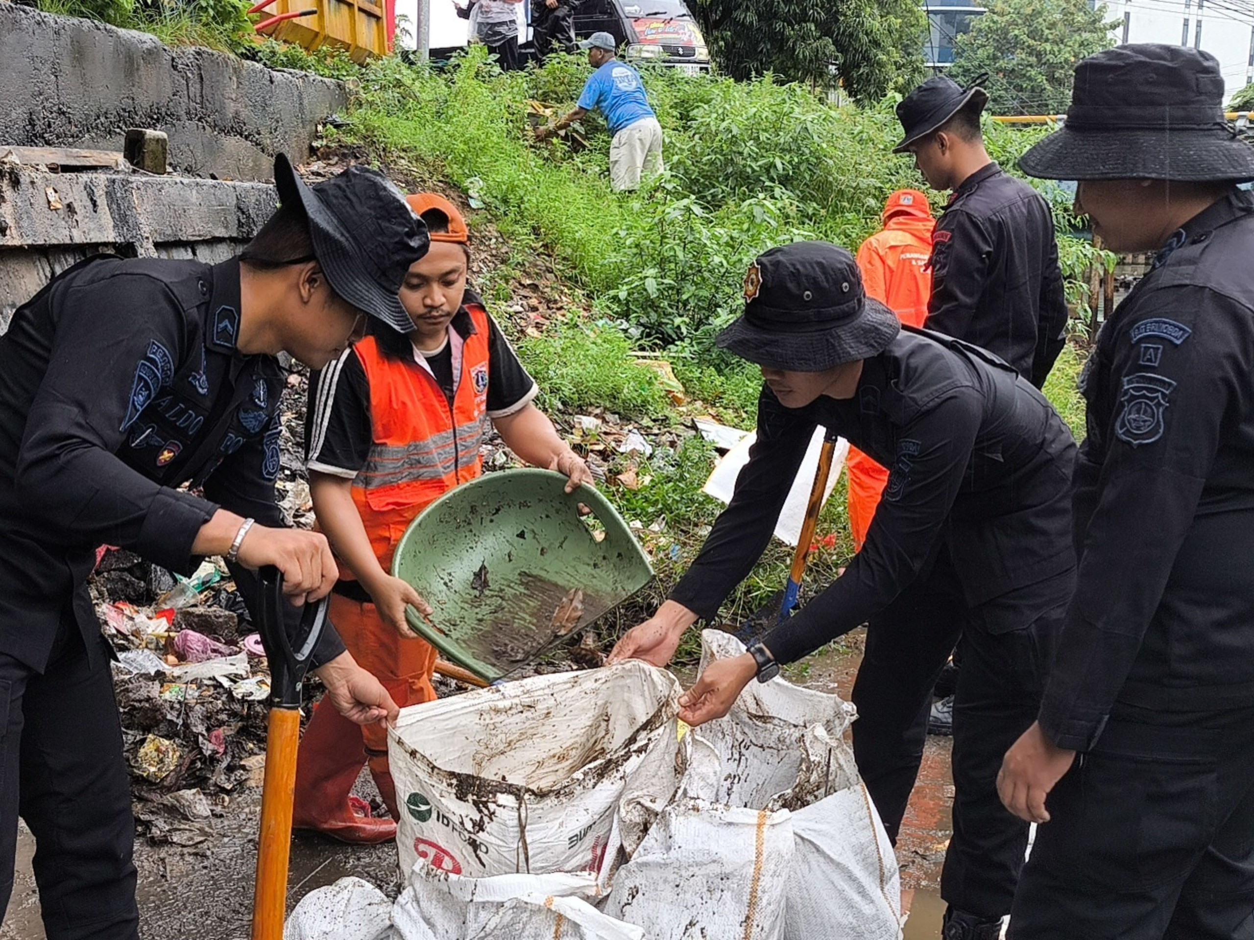 Brimob Metro Jaya Bersama Warga Bersihkan Bantaran Kali di Senen