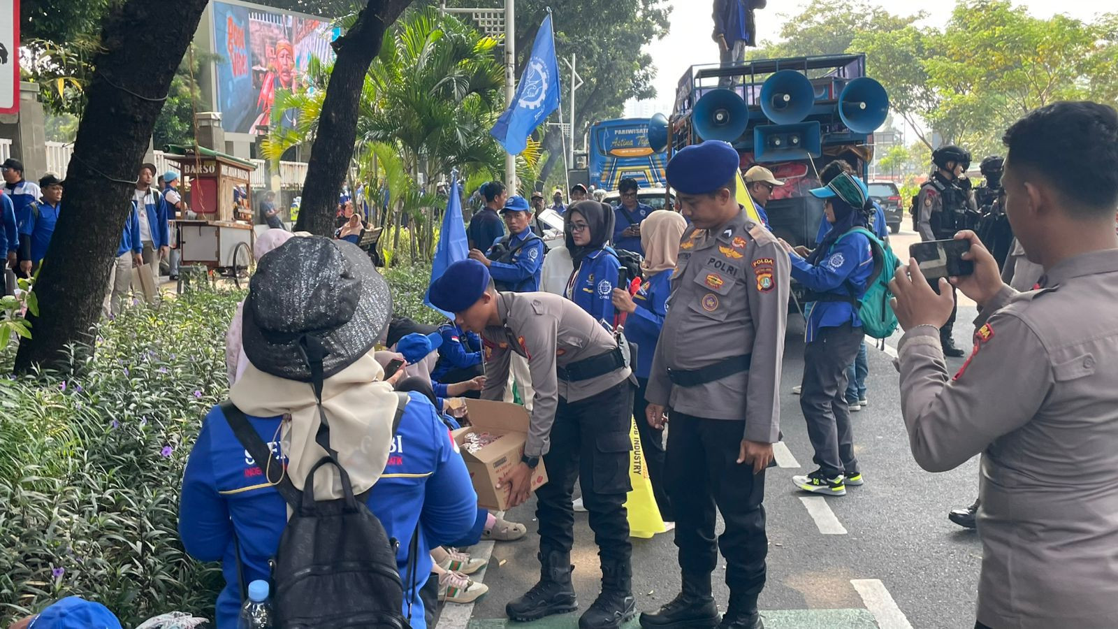 Polisi Bagikan 500 Duz Air Mineral Dan Permen Untuk Massa Buruh Di DPR