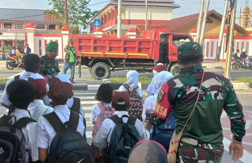 Peduli Keselamatan Anak Sekolah, Secara Rutin Babinsa Koramil Jajaran Kodim 1710/Mimika Bantu Seberangkan Jalan