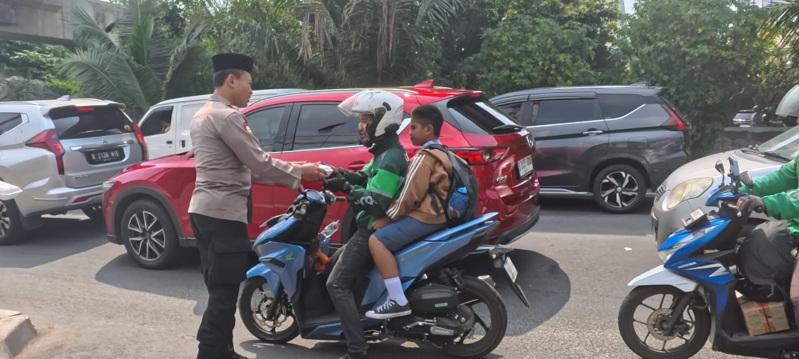 Polsek Kelapa Gading Bagikan 50 Nasi Kotak kepada Ojol dan Warga dalam Program Jumat Peduli