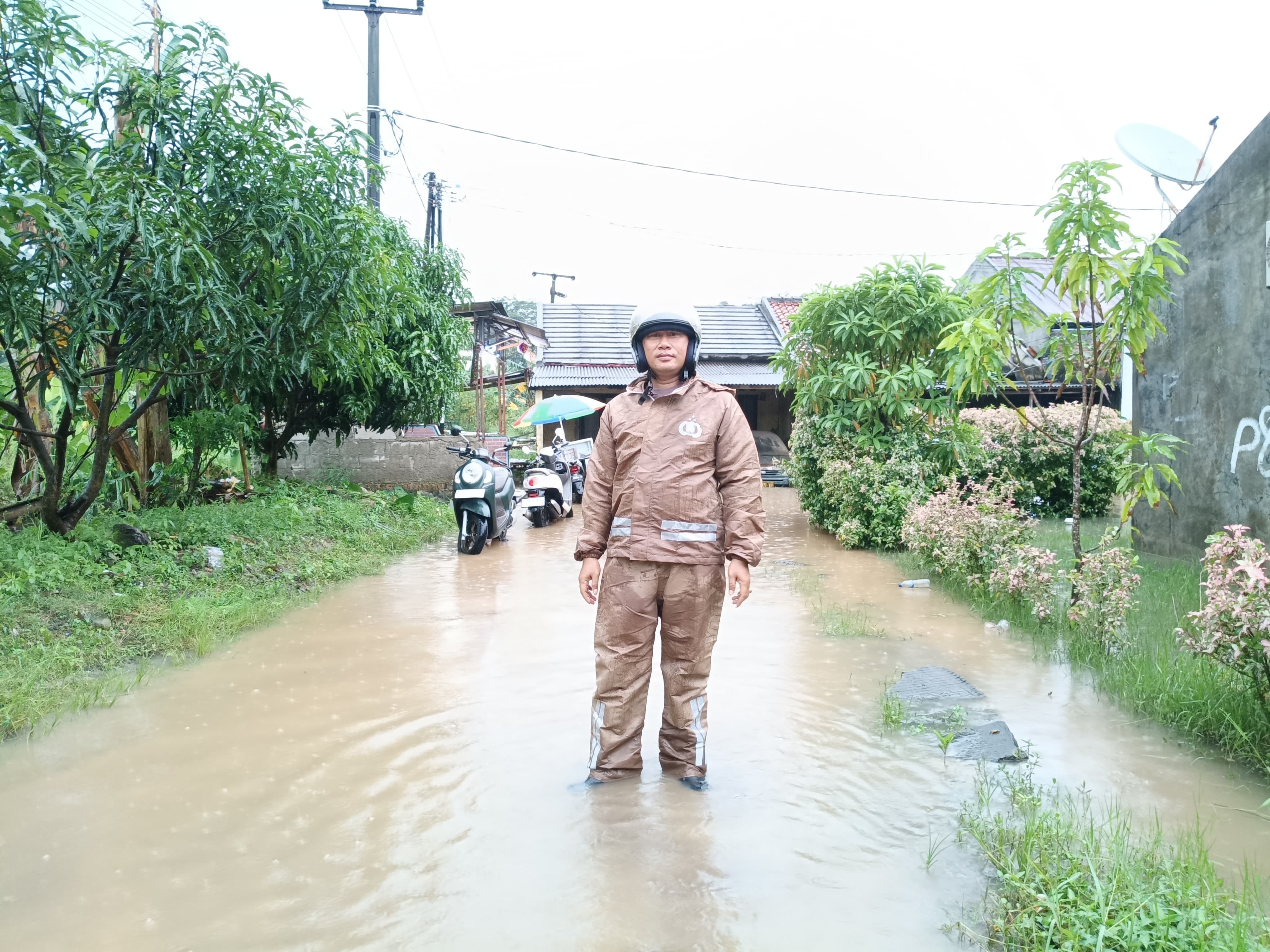 Hujan Intensitas Tinggi, Bhabinkamtibmas Polsek Bantargebang Pantau Genangan Air di Perumahan Kota Baru Cimuning
