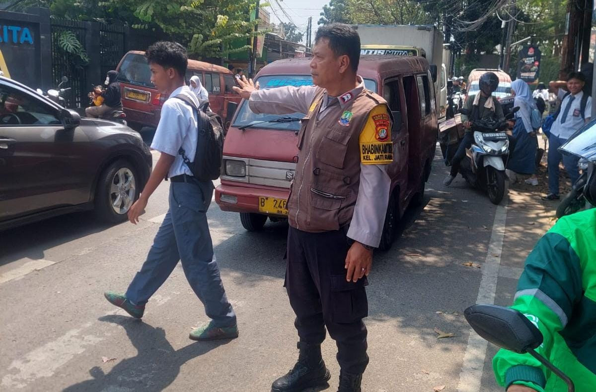 Urai Kepadatan Lalu Lintas,Bhabinkamtibmas Jatirahayu Atur Arus Kendaraan di Depan Sekolah Sandikta