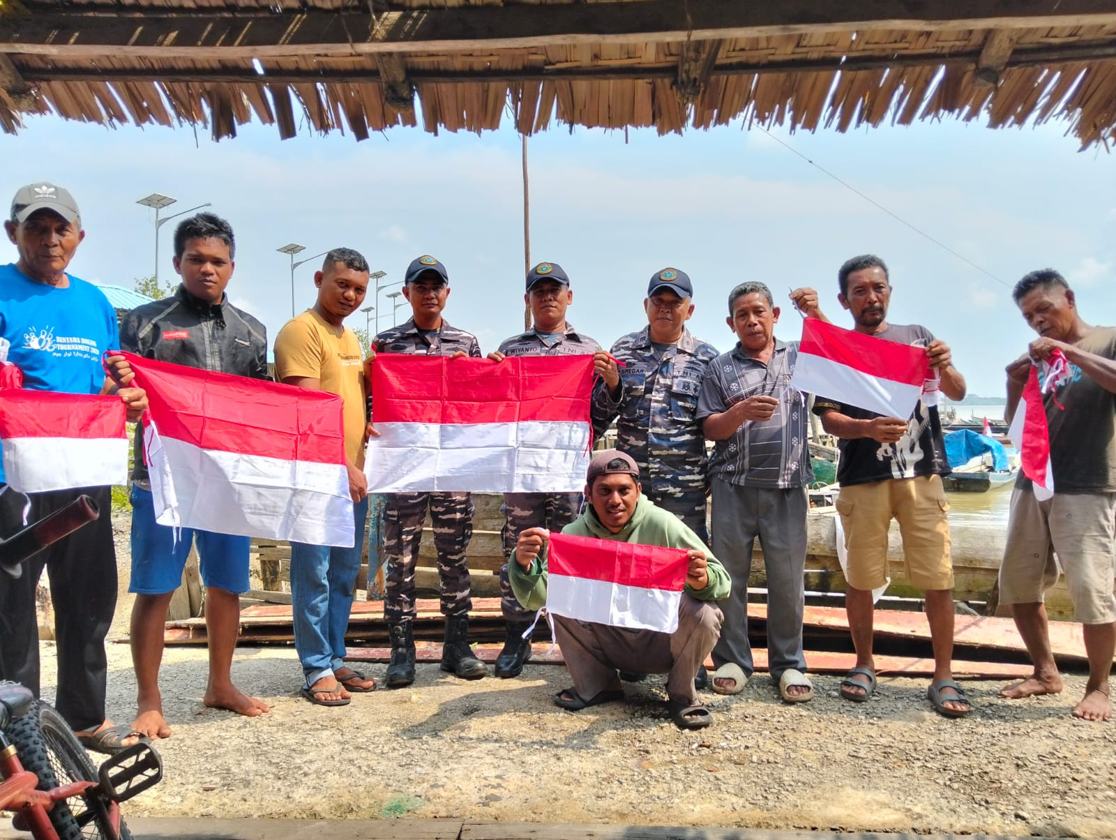 Merah Putihkan Pesisir Riau, Danlanal Dumai Pimpin Pembagian Bendera Merah Putih Kepada Masyarakat Nelayan