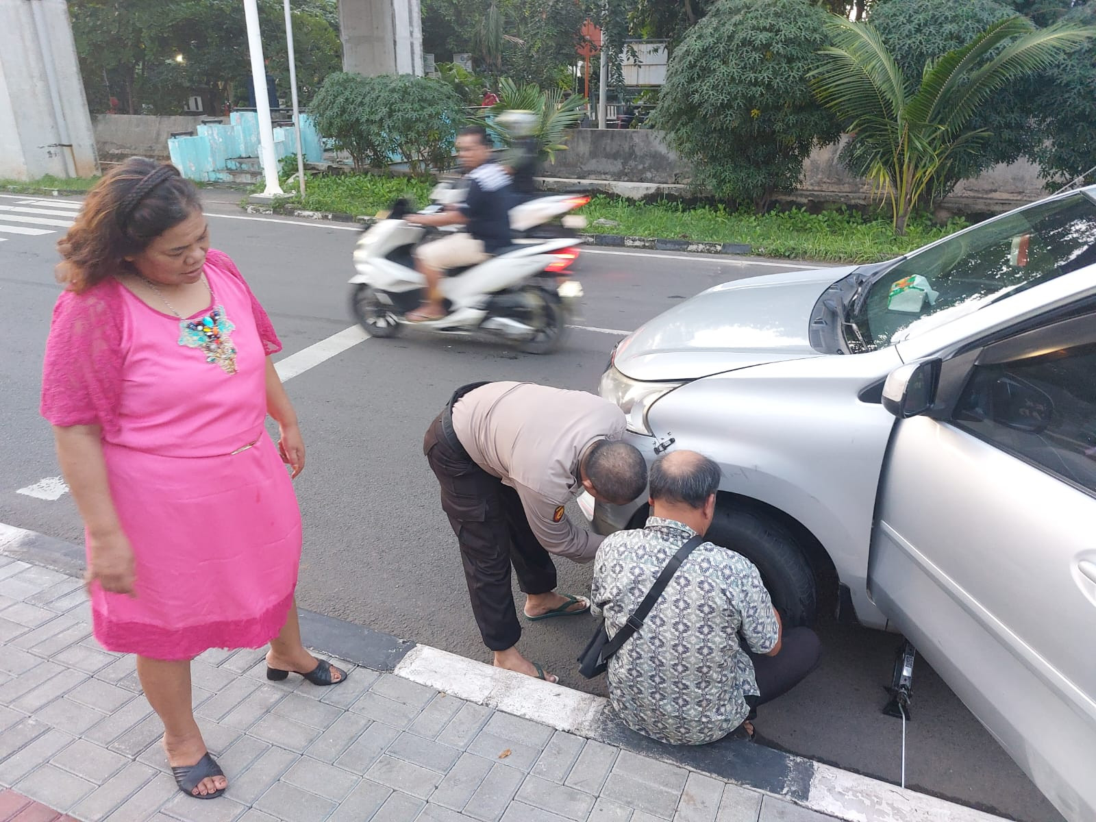 Polisi Sigap Bantu Warga Ganti Ban Bocor di Depan Mako Polsek Kelapa Gading