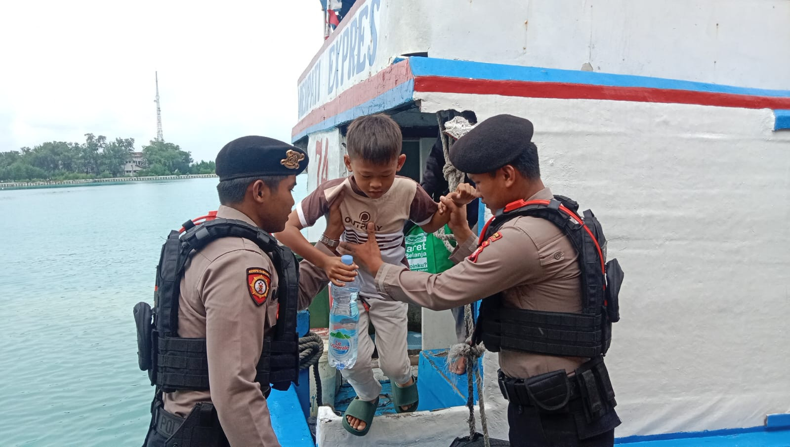 Polisi Baik Polsek Kepulauan Seribu Utara Bantu Penumpang Turun dari Kapal di Dermaga
