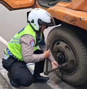Personel Polantas Bantu Pengemudi Truk Ganti Ban di Jalan Ahmad Yani Bekasi