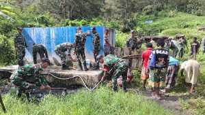 Babinsa Koramil 1715-03/Kurima Bantu Warga Kampung Polimo dalam Kegiatan Kebersihan dan Perbaikan Saluran Air